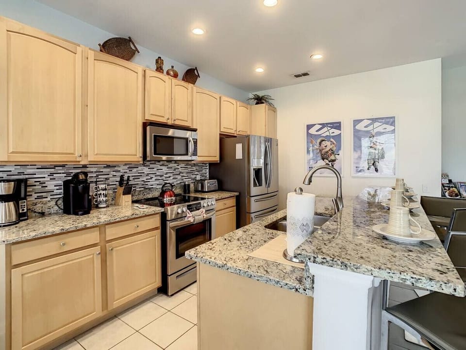 Bright kitchen featuring granite counters and stainless steel appliances.
