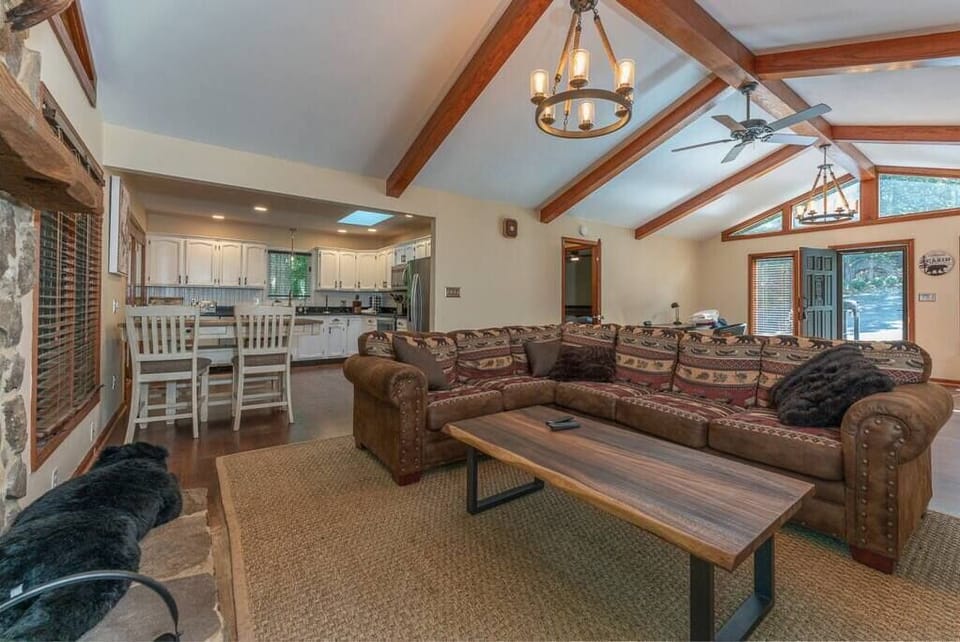 Spacious Living Room w/ Stone Fireplace, Smart TV, Comfy Seating, and Large Windows