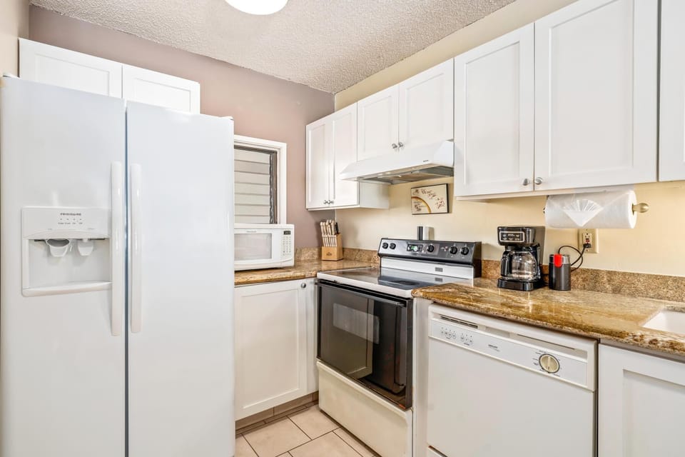 Full kitchen with modern appliances and all utensils provided, ideal for preparing meals before or after your Kona adventures.