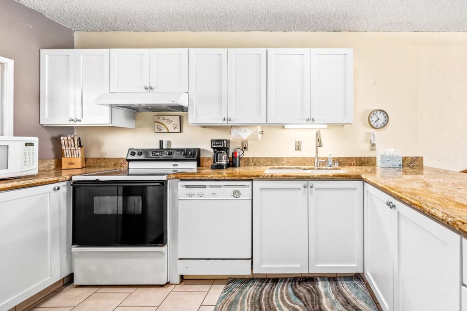 Full kitchen with modern appliances and all utensils provided, ideal for preparing meals before or after your Kona adventures.