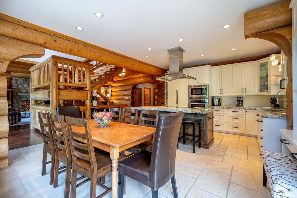 - Open concept kitchen and dining with rustic log details  
- Granite island and wood table create the heart of the home  
- Perfect Whistler cabin for shared meals and warm gatherings  
