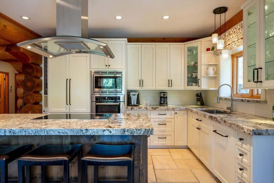 - Bright modern kitchen with granite countertops and island seating  
- White cabinets and stainless appliances enhance alpine style  
- Perfect Whistler setup for family cooking and cozy gatherings  