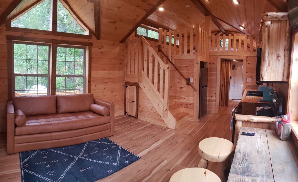 Kitchen/living/dining area of Tiny Toledo. Stairs lead to a loft with a king bed
