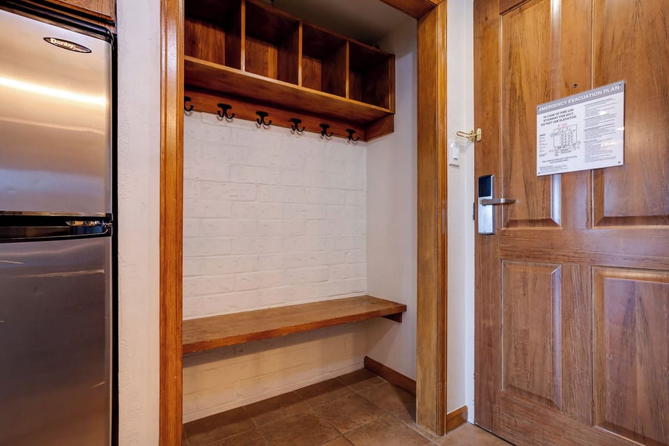 Your personal mudroom awaits with custom wooden shelving, coat hooks, and bench seating for easy gear storage after mountain adventures.