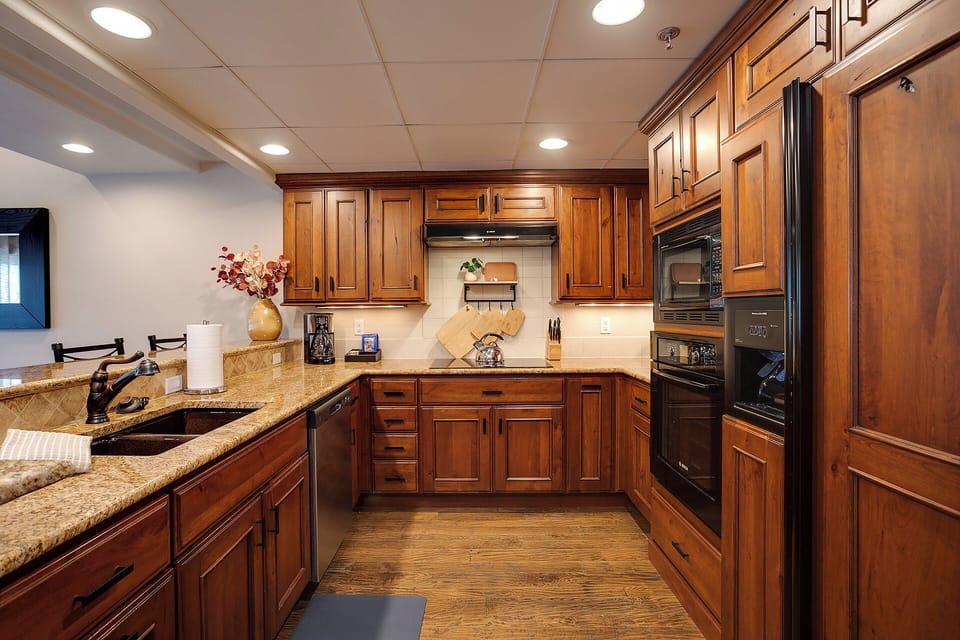 Cook your favorite meals in this elegant kitchen featuring rich wood cabinetry, granite countertops, and premium appliances for your culinary adventures.