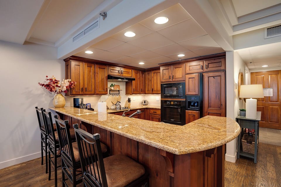 Your gourmet kitchen features rich wood cabinetry, granite countertops, and top-tier appliances for memorable cooking experiences.