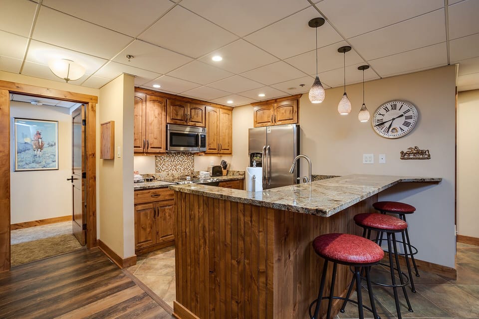 Your fully equipped kitchen awaits with granite countertops, stainless appliances, and a breakfast bar perfect for morning coffee or casual dining.