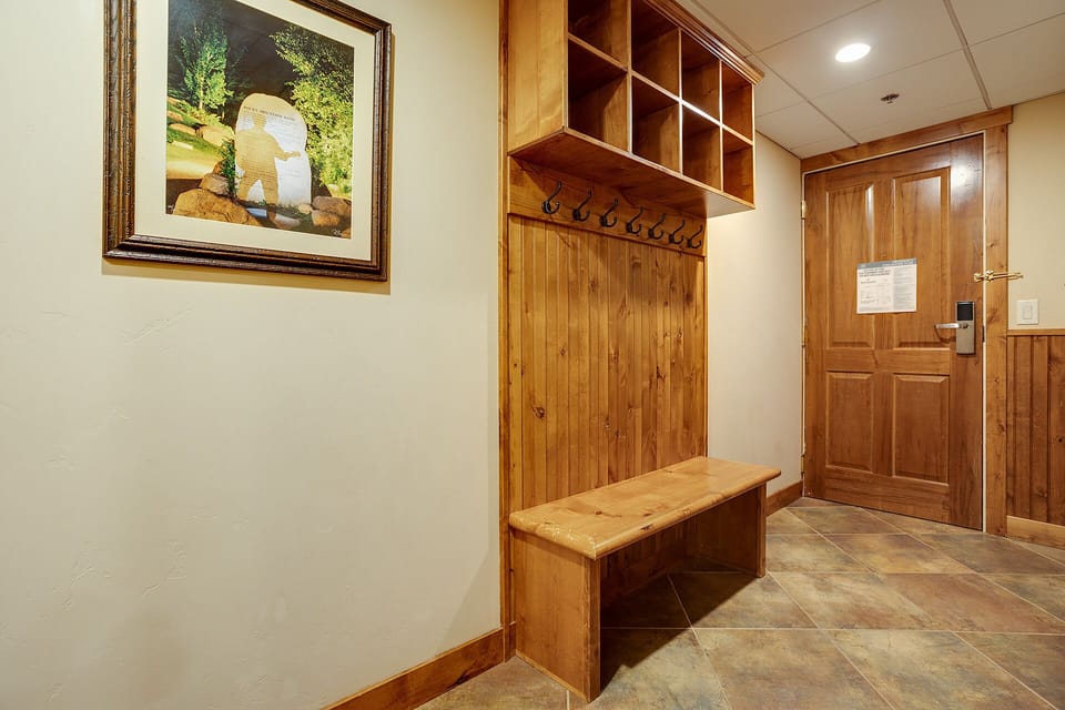 Step into your private mudroom with custom wooden storage cubby and bench—perfect for organizing gear after mountain adventures.