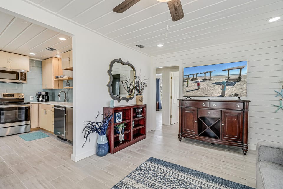 Unwind in your bright, coastal-inspired living space where shiplap walls and warm wood beams create the perfect backdrop for relaxing evenings.