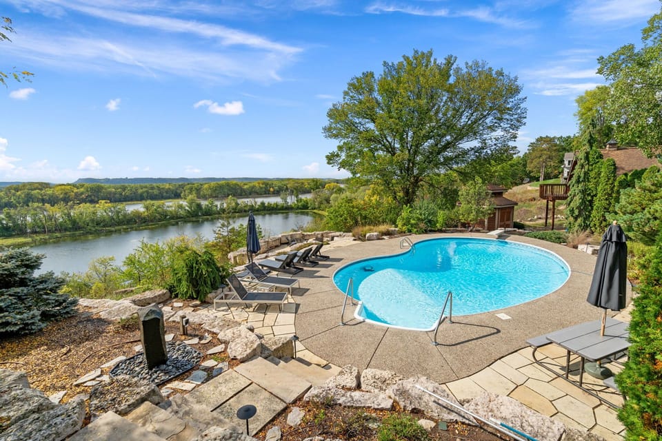 Stunning riverside retreat with private pool surrounded by lush landscaping and breathtaking water views.