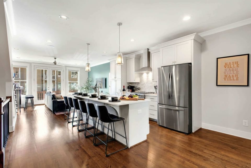 Open kitchen flows straight into the living room, so the cook stays part of the action while twelve guests gather around for Nashville meals and group toasts