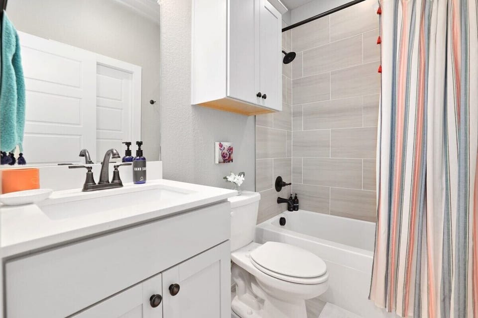 This bath has a combination tub/shower and a single sink. It can also be reached through the main first floor hallway.