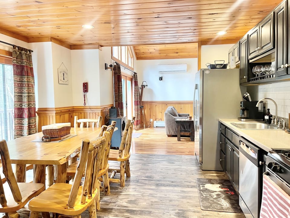 The warm, light-filled kitchen has french doors leading to an expansive front deck with a Trex dining table.  