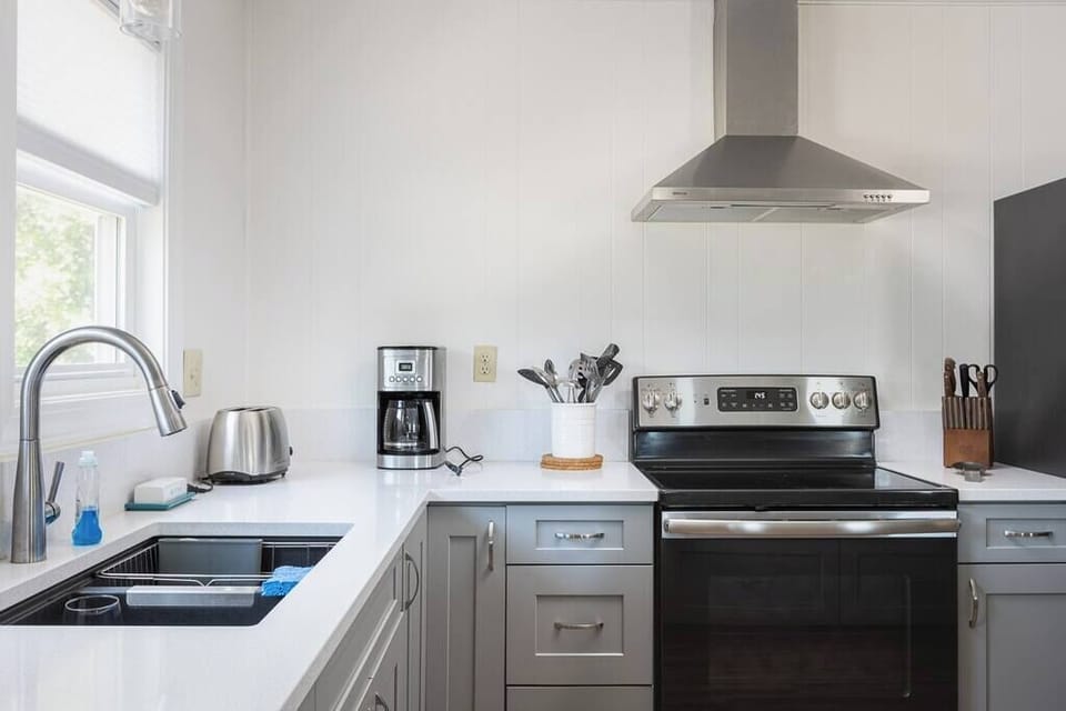 Top Level Fully Equipped Kitchen with Refrigerator, Oven, Microwave, Coffee Maker, and Toaster plus a Breakfast Bar with Seating and Windows that bring in Plenty of Natural Light
