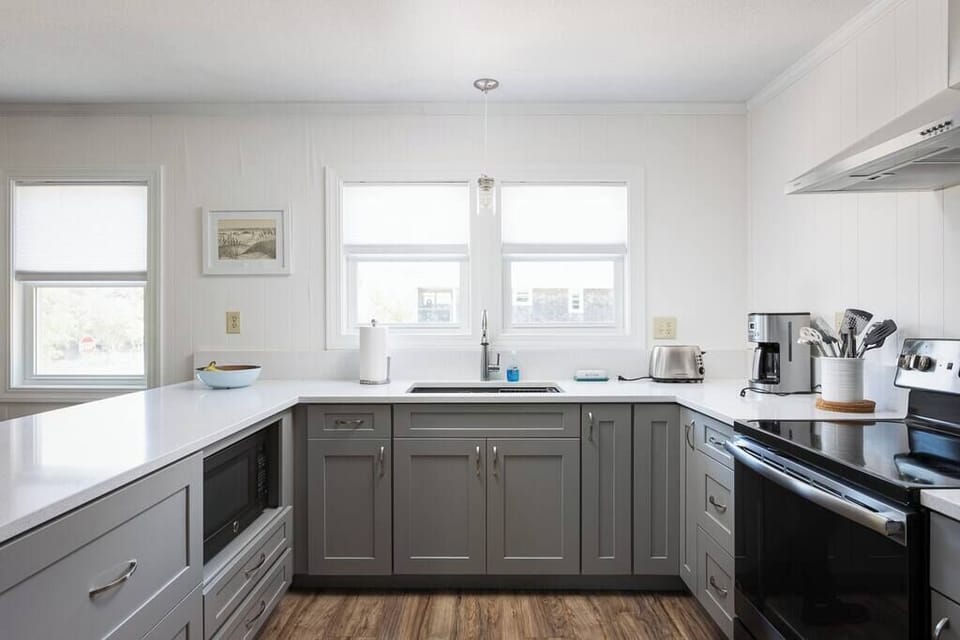 Top Level Fully Equipped Kitchen with Refrigerator, Oven, Microwave, Coffee Maker, and Toaster plus a Breakfast Bar with Seating and Windows that bring in Plenty of Natural Light