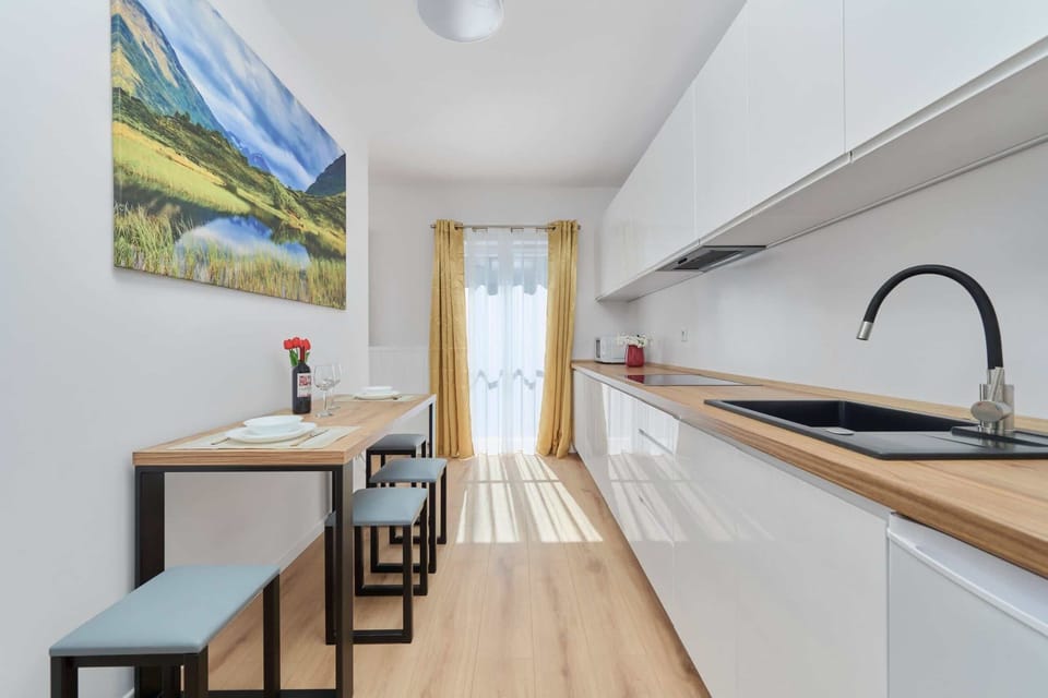 Kitchenette with fridge and freezer, electric hob, electric kettle, microwave and dining area.
