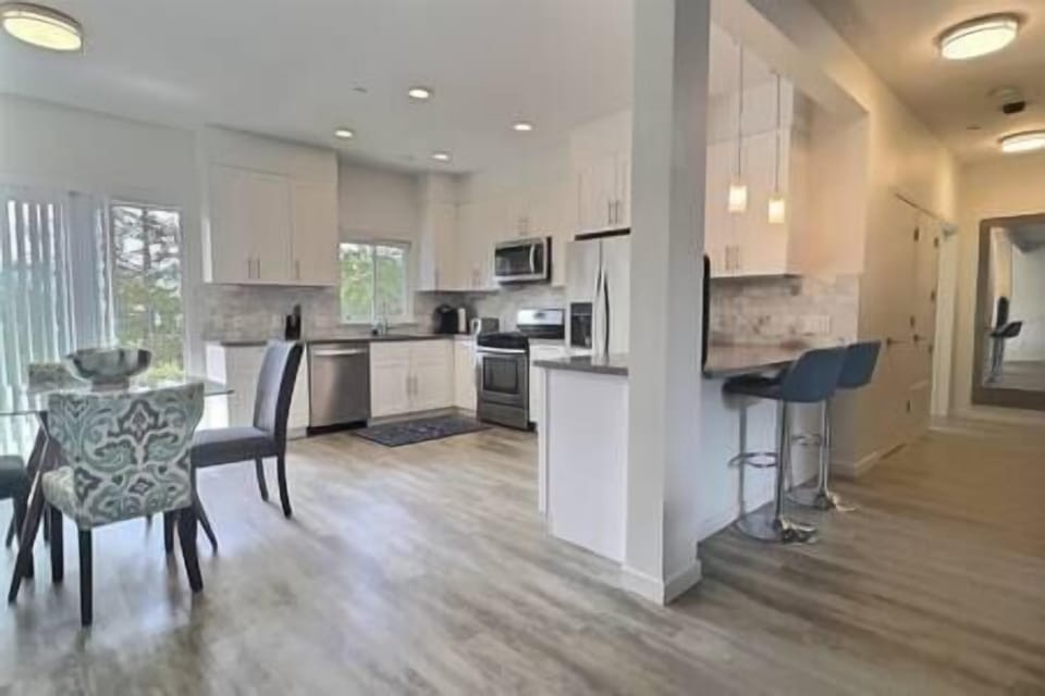 Fully-equipped kitchen with bar seating, dining nook, and patio with olive orchard views.