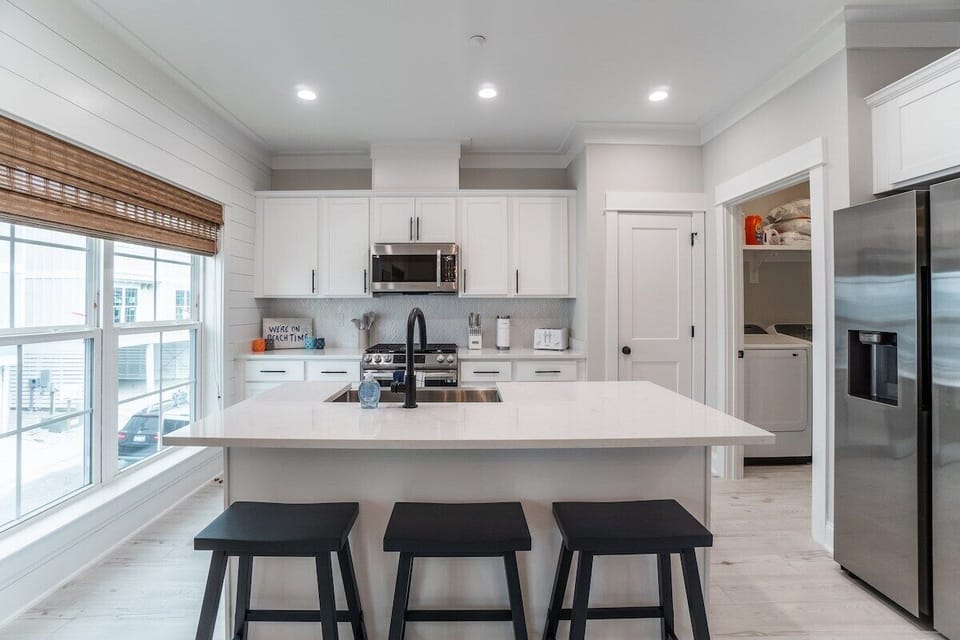 Kitchen Island, View of Laundry room.  All Smart appliances in Stainless Steel.  3 bar stools for seating.  