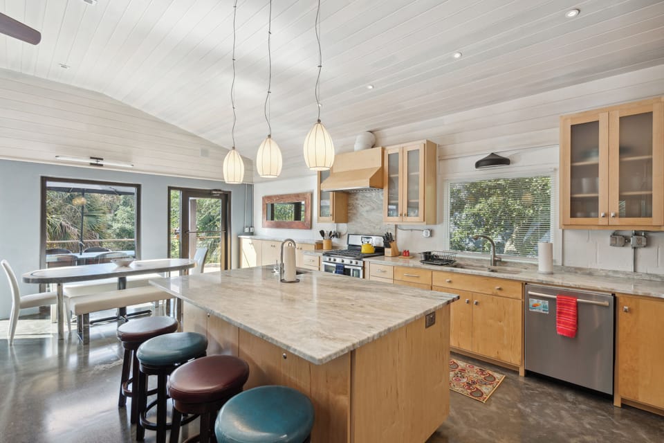 Full kitchen and modern appliances with a breakfast bar and dining area.