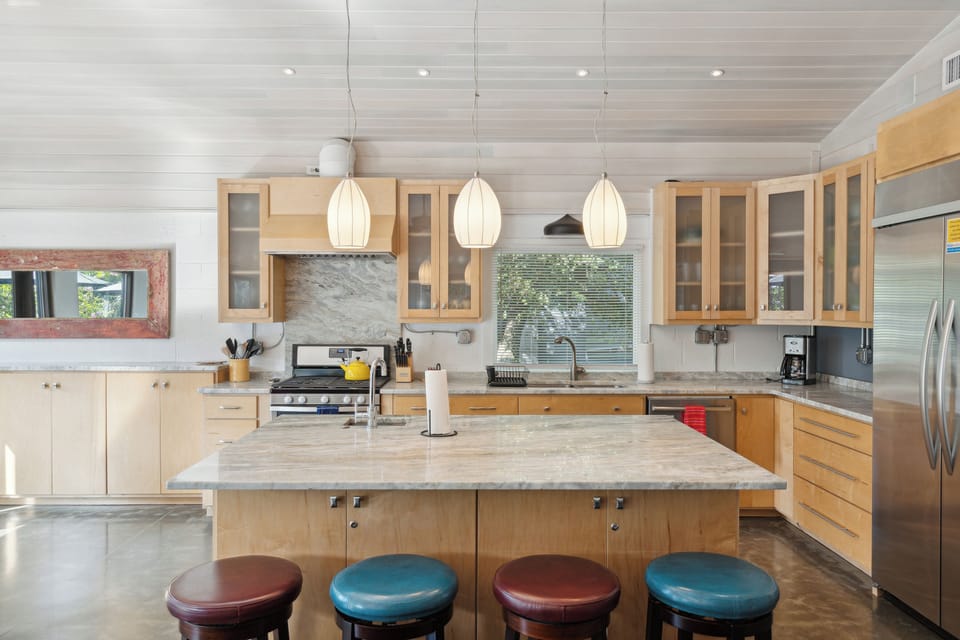 Full kitchen and modern appliances with a breakfast bar and dining area.