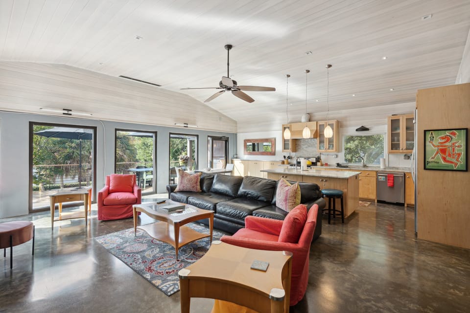 The open living room with multiple comfortable seating areas and queen size sleeper sofa and large TV.