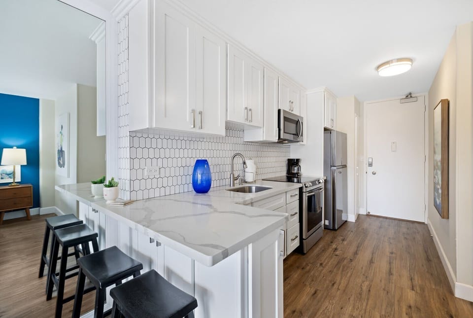 A cozy wooden kitchen featuring essential appliances and stocked wit some basics needed for cooking.