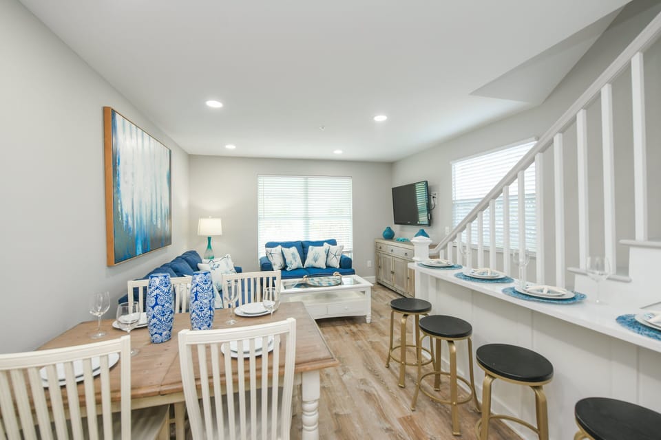 The dining area flows effortlessly into the living room, creating a comfortable space for meals, games, and conversation.