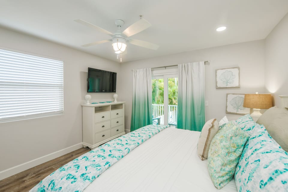 Soft neutrals and pops of turquoise set a relaxed tone in this spacious en suite, complete with a flat-screen TV and direct balcony access.