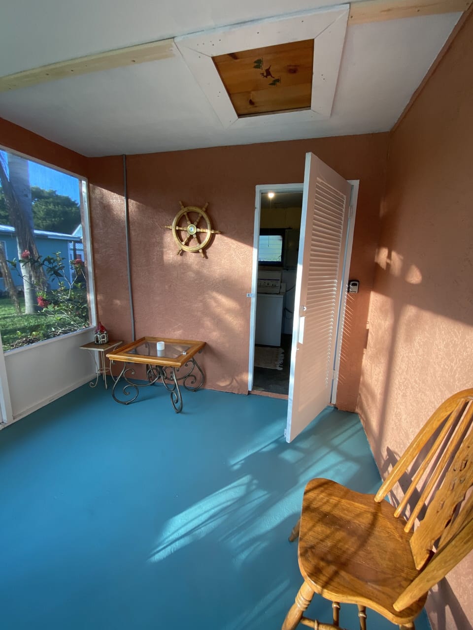 The washer/dryer room is behind the door at the back of the porch