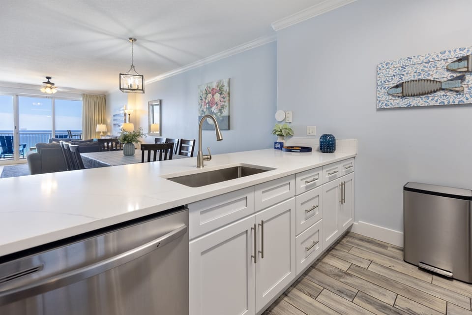 Your sleek white kitchen features modern appliances and opens beautifully to the bright living area with stunning ocean views.
