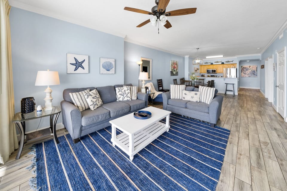 Unwind in your coastal-themed living space with plush seating, nautical touches, and an open layout that flows into the fully equipped kitchen.