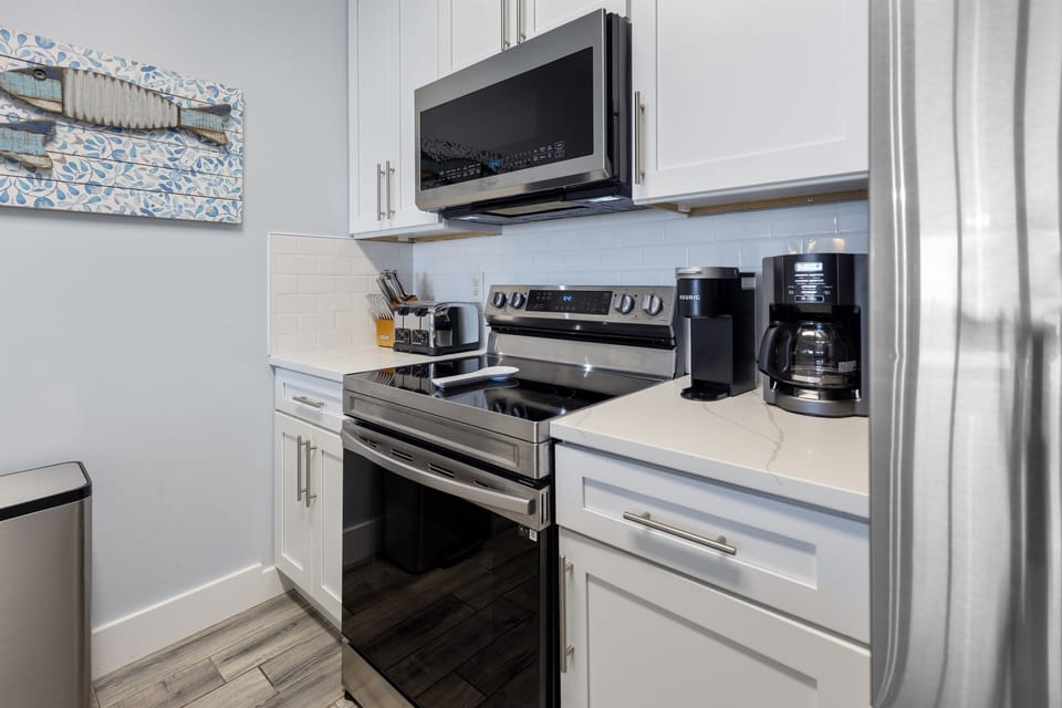 Your fully equipped kitchen features stainless steel appliances, crisp white cabinetry, and everything you need to prepare meals during your stay.