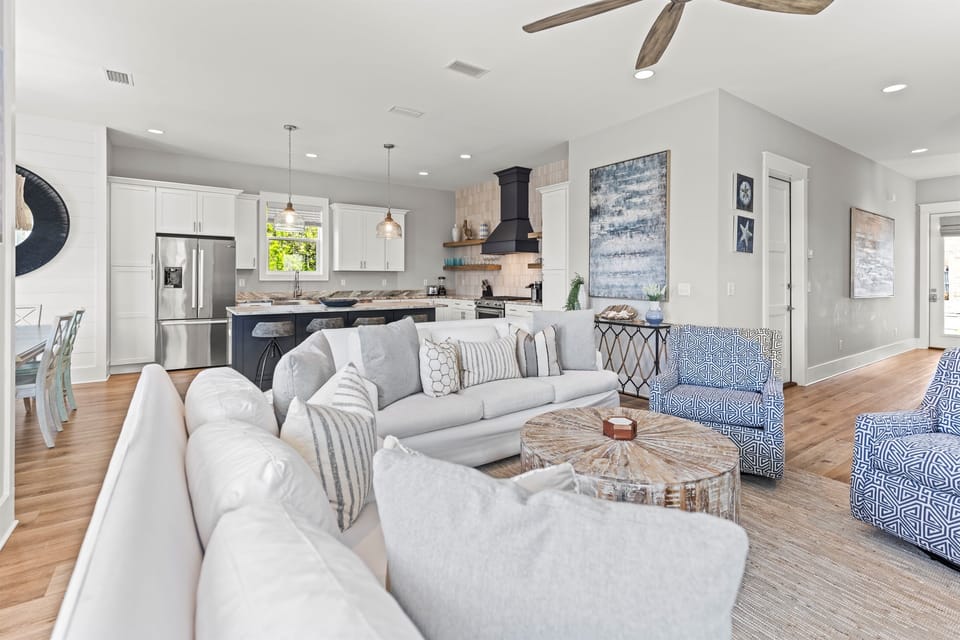 Sink into plush sofas in your open-concept living space, where coastal blues meet modern comfort and the fully equipped kitchen awaits your culinary adventures.