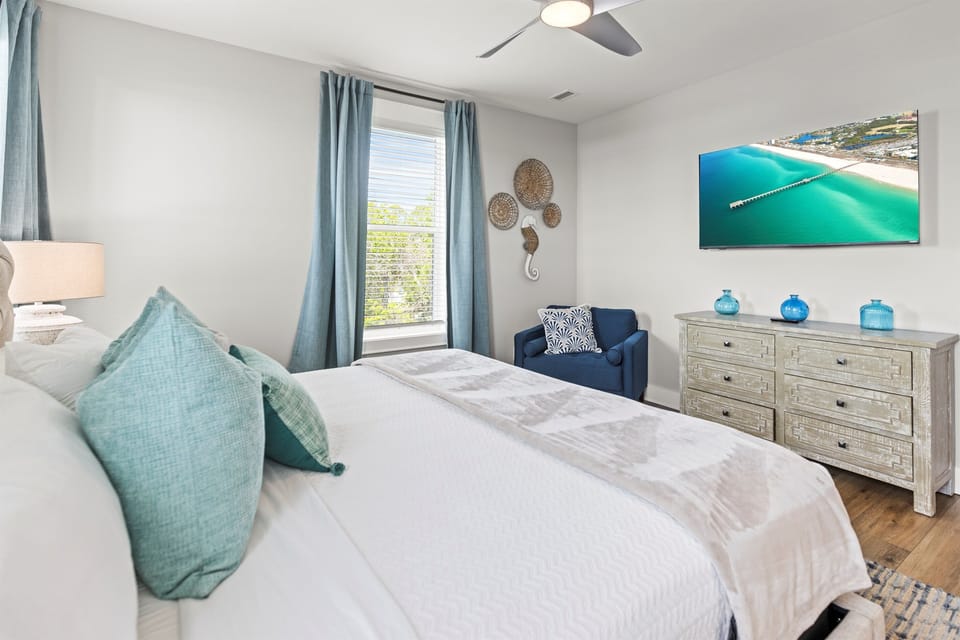 Drift into peaceful dreams in your serene coastal bedroom, where soft turquoise accents and ocean art create a tranquil retreat.