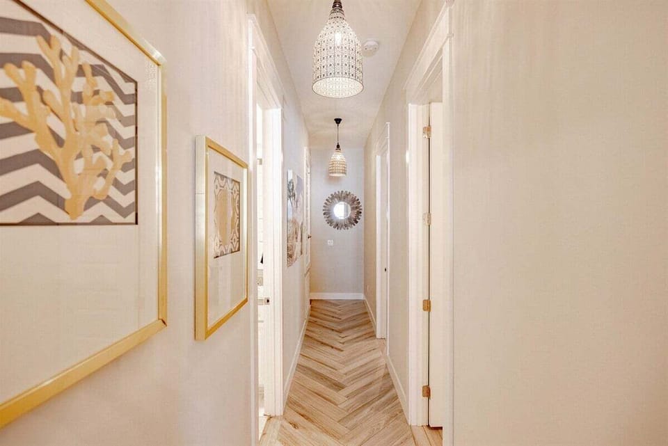 A long, inviting hallway with soft lighting, leading to beautifully decorated bedrooms.