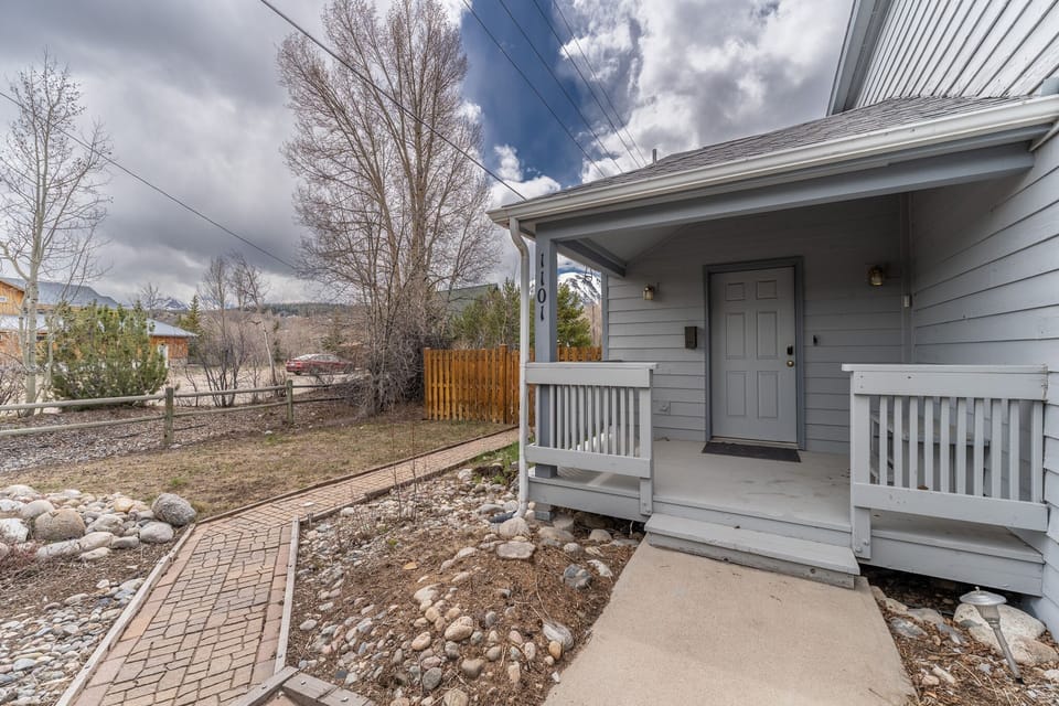 Charming property entrance with welcoming front porch and mountain views in a peaceful residential neighborhood.