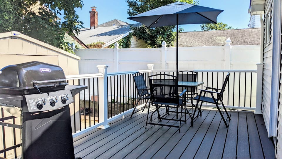 Large backyard deck with seating and gas grill