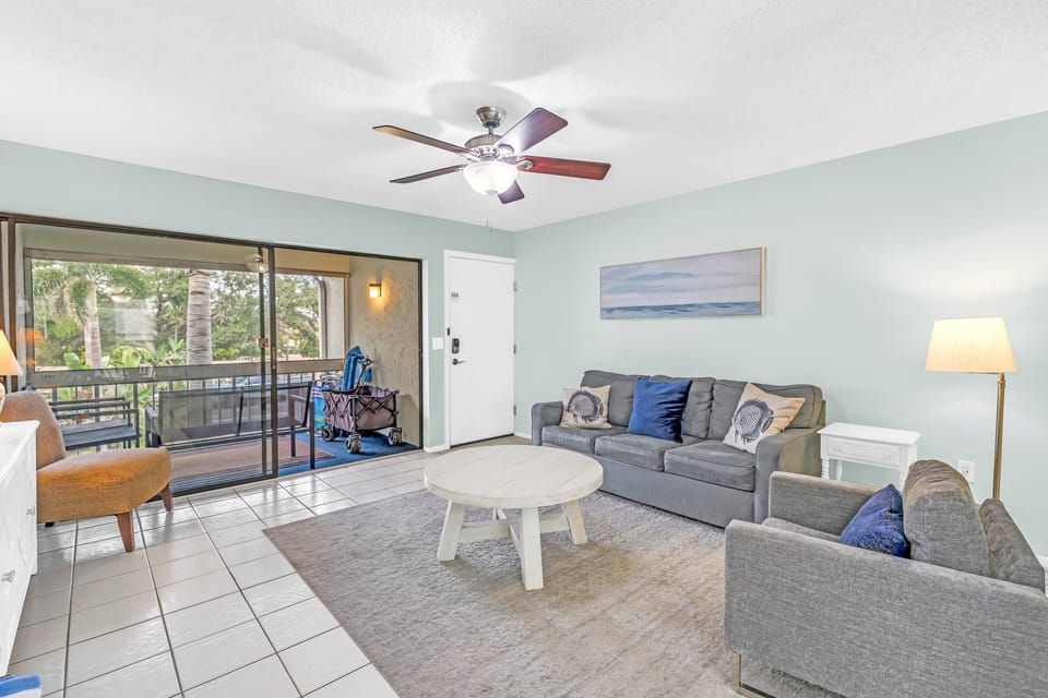 Living area spacious and sunny, opens to screened in balcony with royal palms view.
