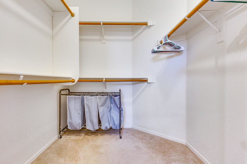 Huge Closet with plenty of hangers and laundry bin.
