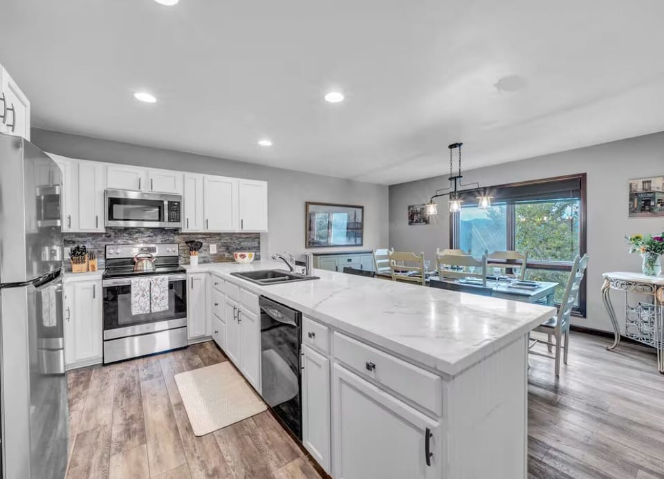 Modern kitchen with large island, stainless appliances, and dining for 6+
