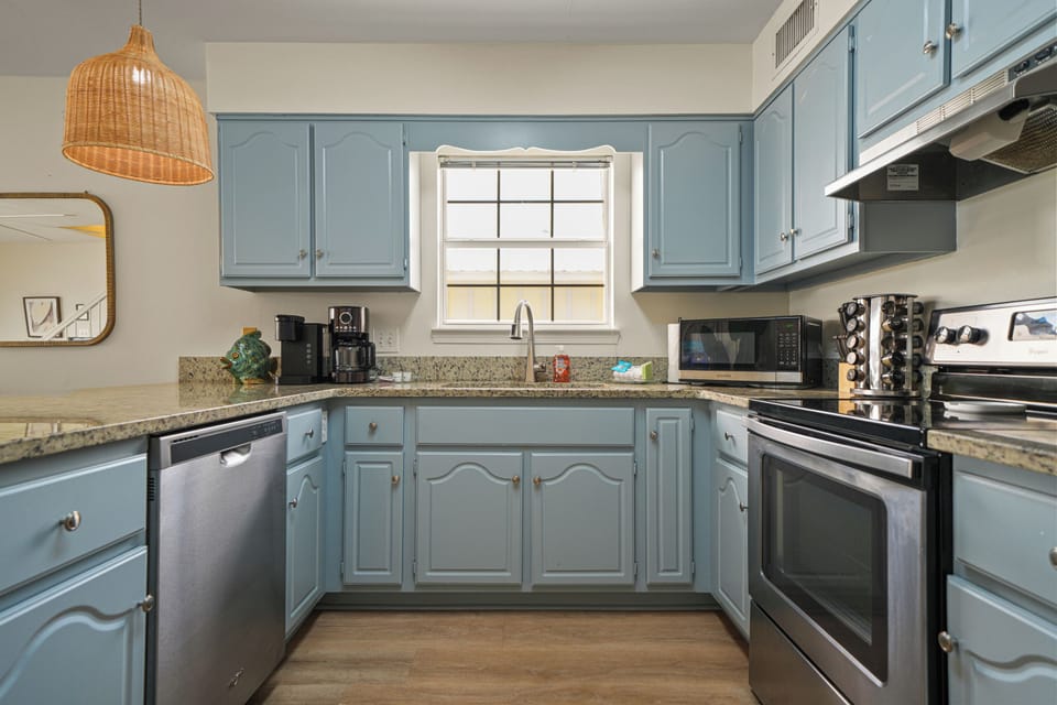 Unit A kitchen featuring stainless steel appliances, ample cabinet space, and a full suite of essentials. Designed for easy meal prep and gathering during your Gulf Shores stay.