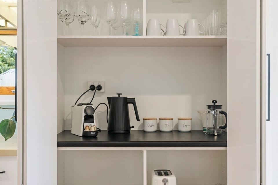 Modern kitchen with all the modern appliances including coffee machine, ice maker, dishwasher.