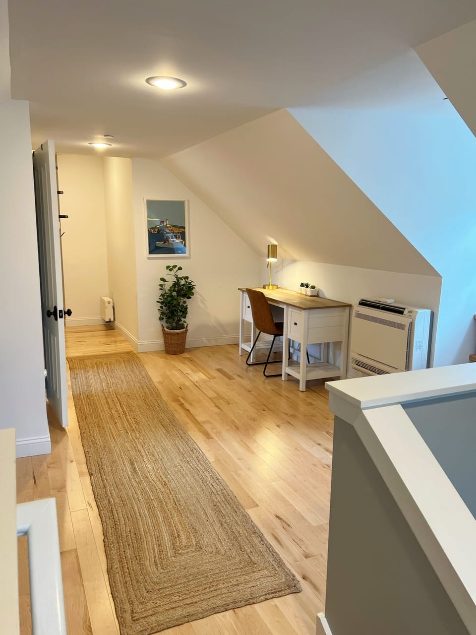 Stairs to the 3rd floor lead to a long hallway with open office space + bedrooms