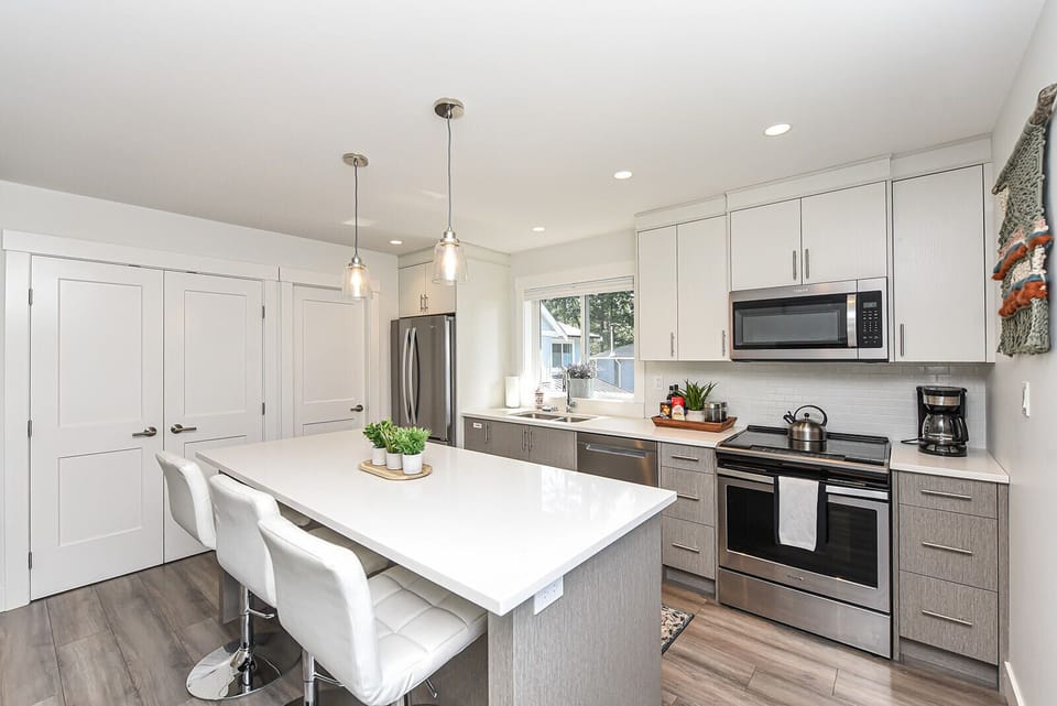 Modern kitchen with stainless steel appliances and quartz countertops. 