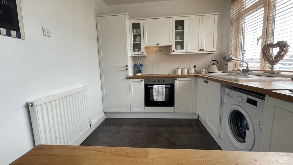 The kitchen features fridge freezer, electric hob, washing machine and microwave