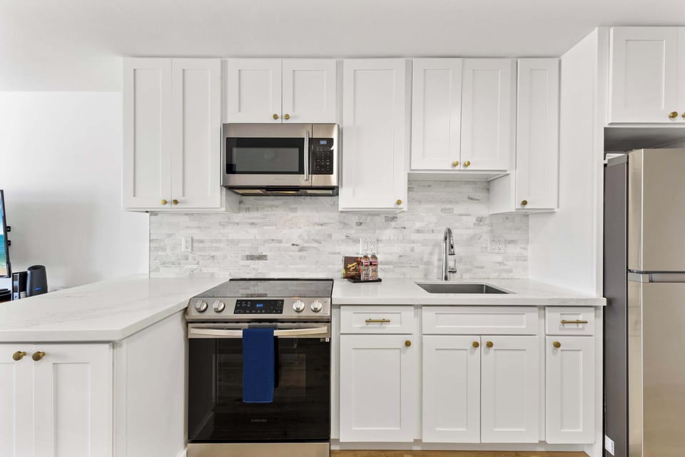Modern kitchen with basic appliances, sleek counters, and stylish cabinetry