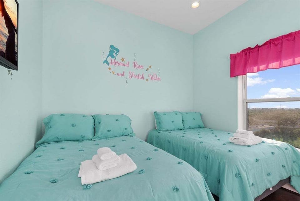 Light and airy bedroom with two twin beds and beach-inspired décor for a relaxing vacation feel.