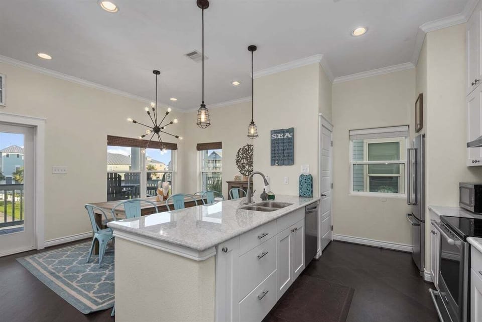 Contemporary kitchen with large island, granite countertops, and modern appliances perfect for preparing meals during your stay.