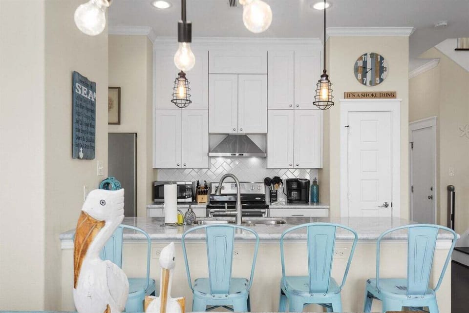 Beautiful kitchen with bar stools, pendant lighting, and open layout connecting seamlessly to the dining and living areas.