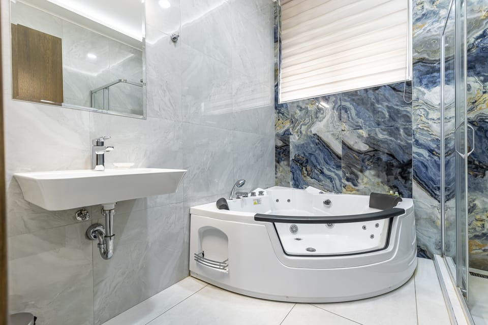 Grand Room, 1 King Bed, Hot Tub | Bathroom | Combined shower/tub, jetted tub, rainfall showerhead, free toiletries